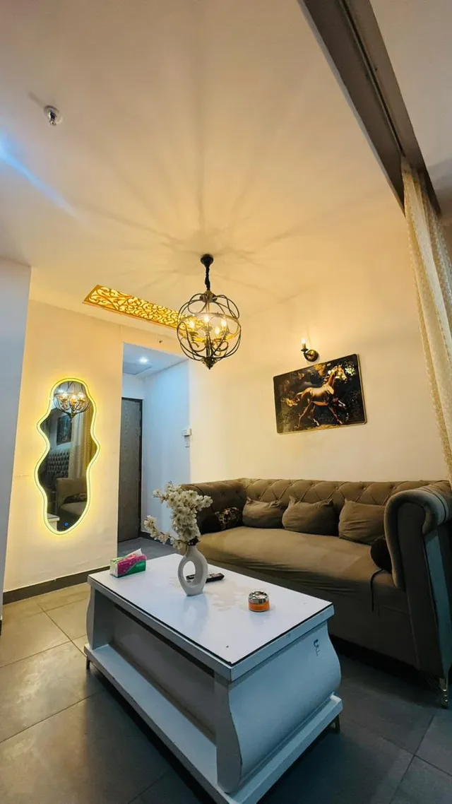 A compact living area with upholstered seating, a coffee table and a pendant light.