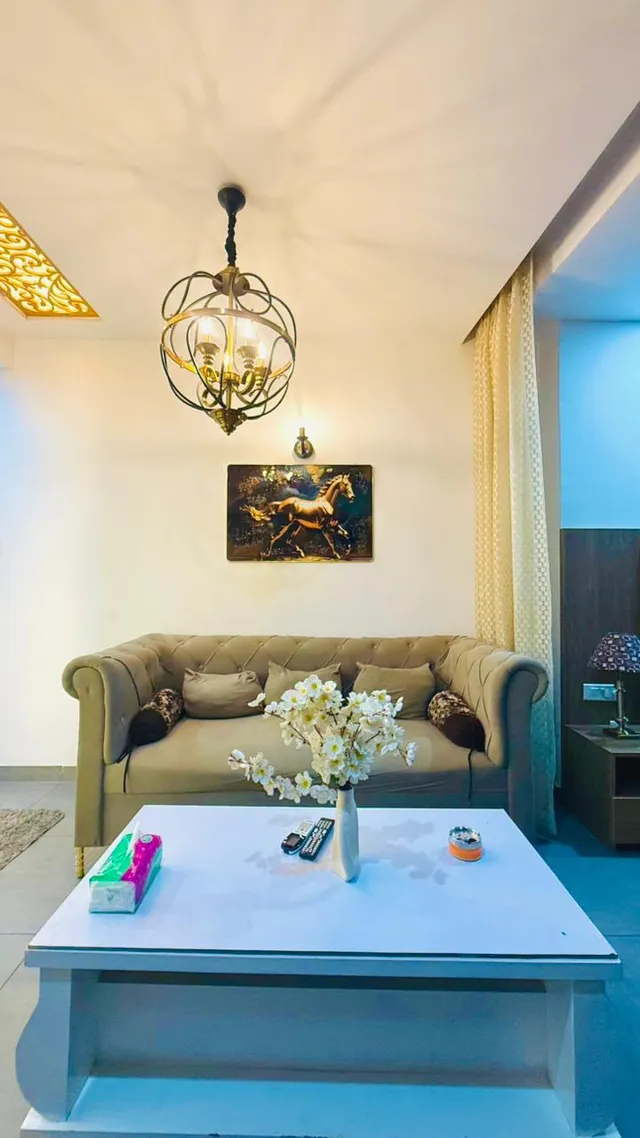 A front view of the living seating, pendant light and a light-coloured coffee table.